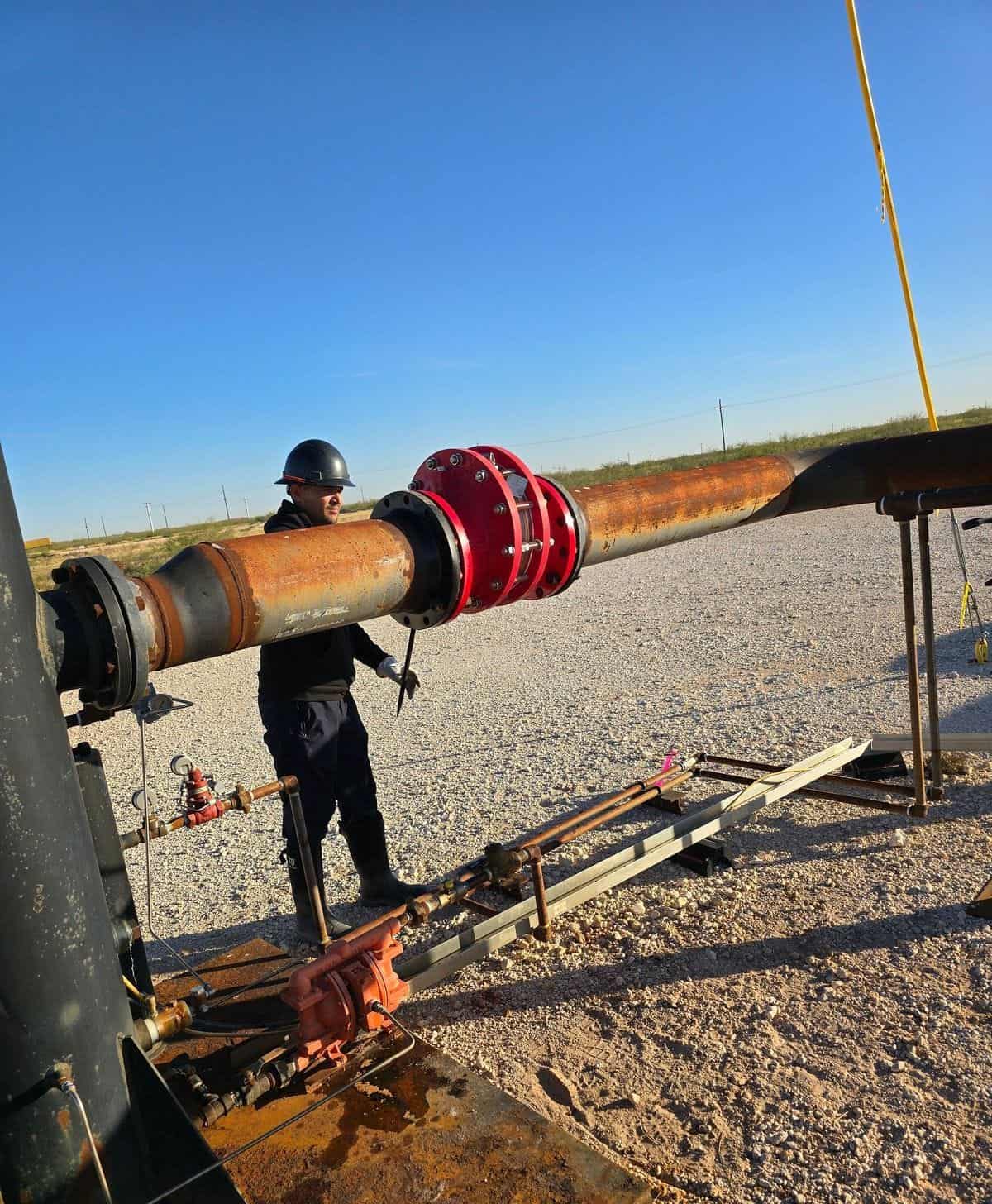 An ROS technician servicing a flame arrestor on a flare line in the Permian Basin