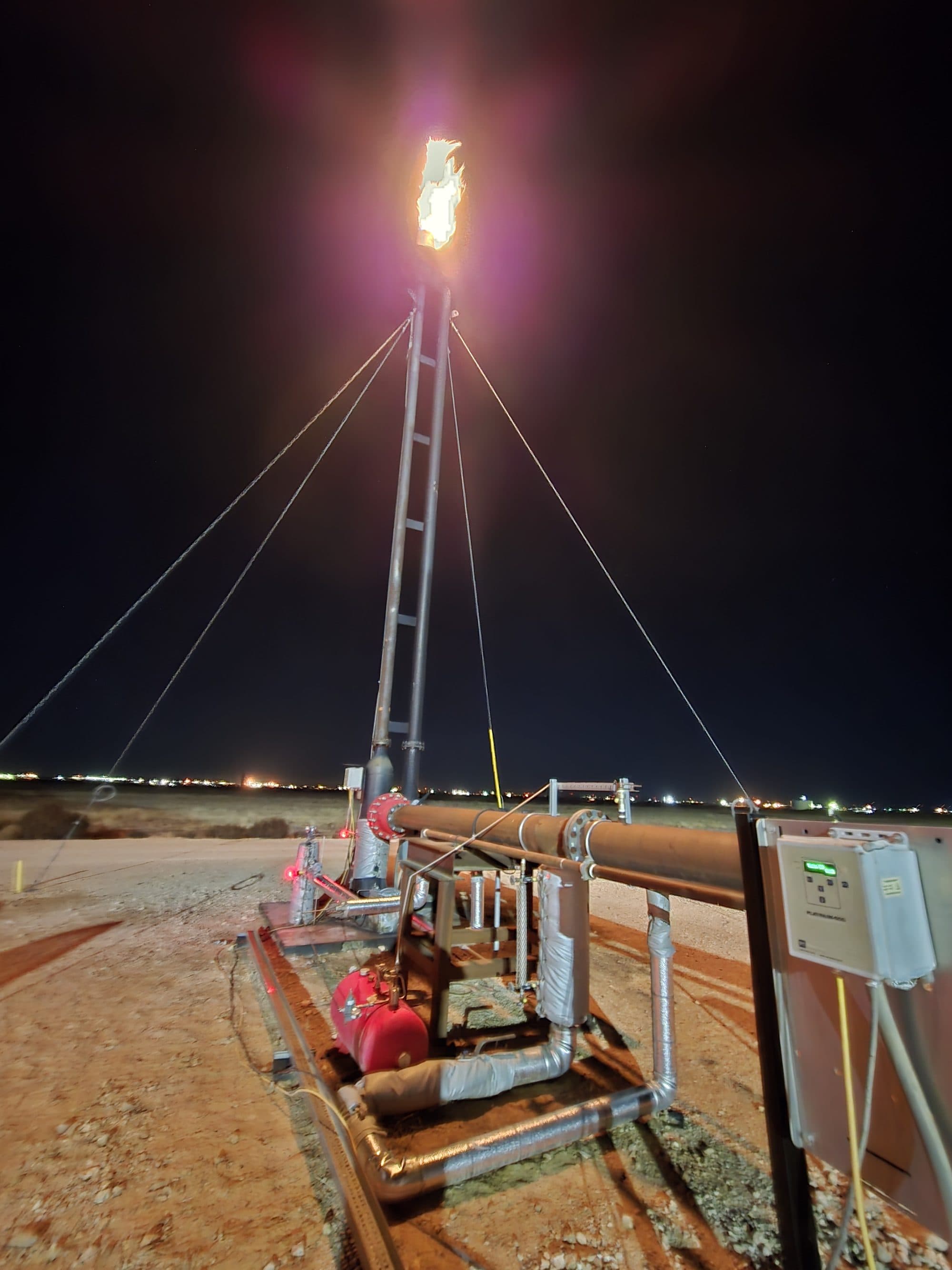 ROS-serviced flare burning bright at a Permian site at night