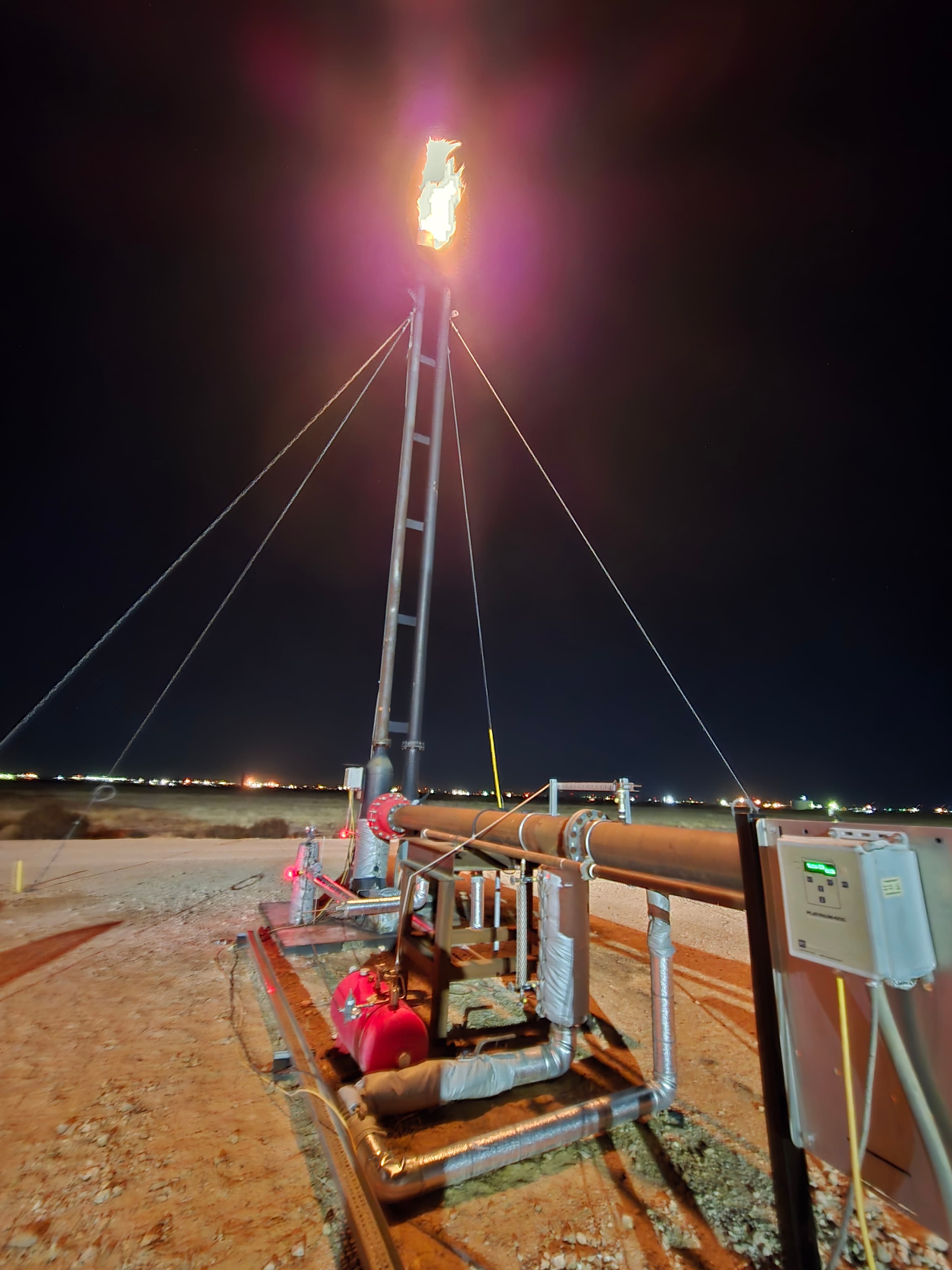 ROS-serviced flare burning bright at a Permian site at night
