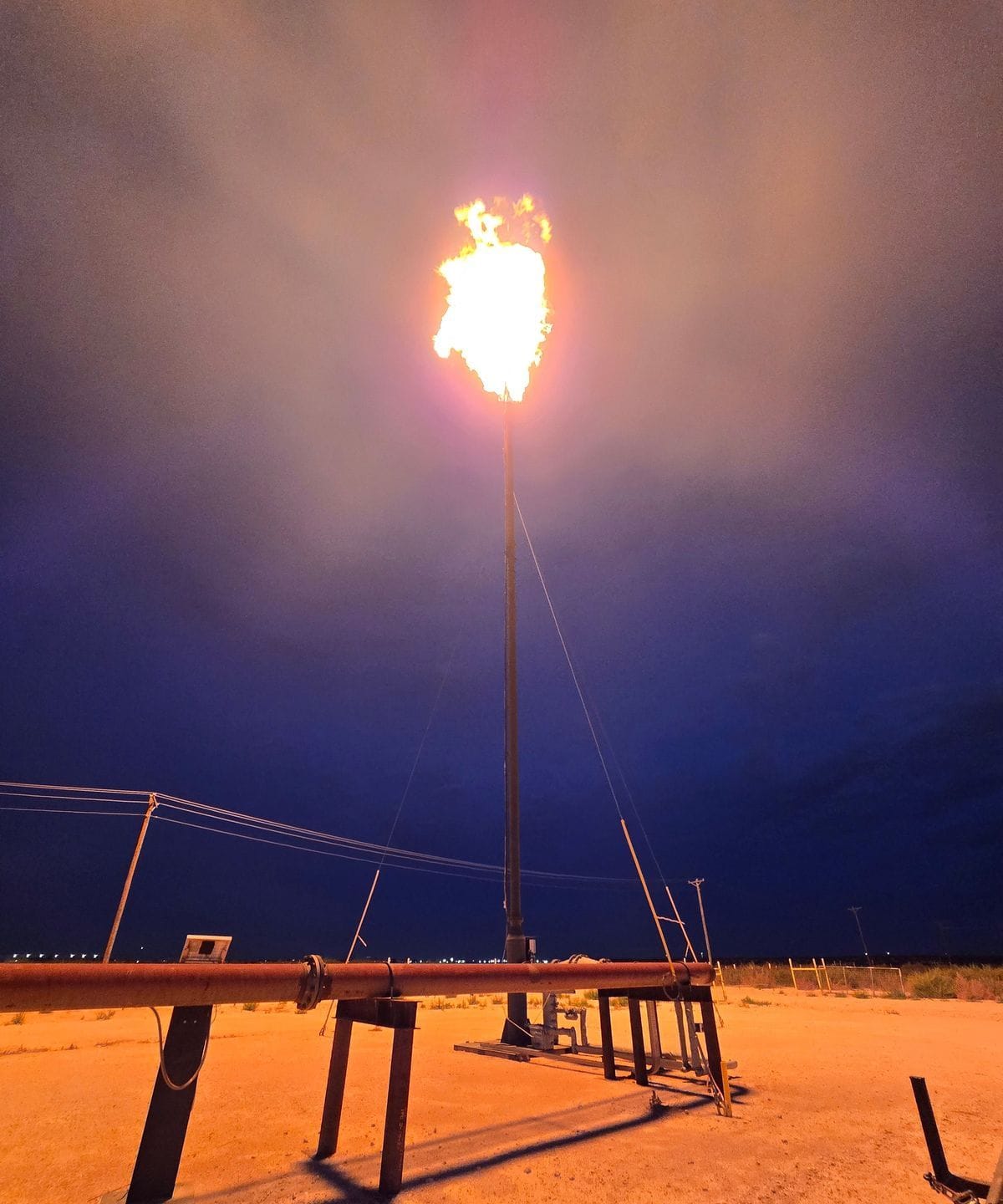 A flare lit and burning clean at dawn on a Permian Basin lease