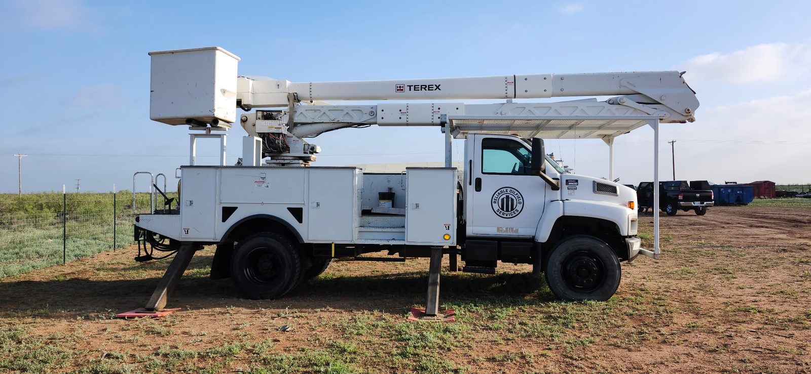 Reliable Oilfield Services Terex bucket truck and man-lift, side profile, at the ROS yard in the Permian Basin